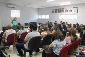 Pessoas sentadas em auditório assistindo a palestra da promotora Amparo Paz