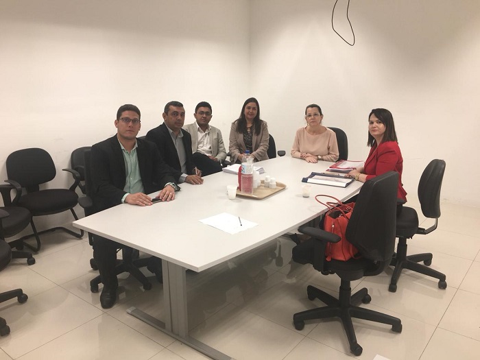 Pessoas sentadas em volta de uma mesa