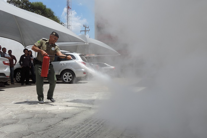 Homem manuseando um extintor de incêndio 