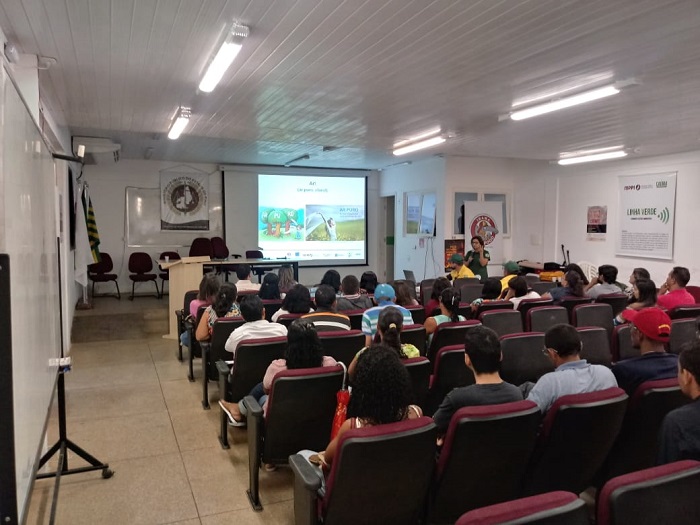 Pessoas em auditório sentadas assistindo palestras