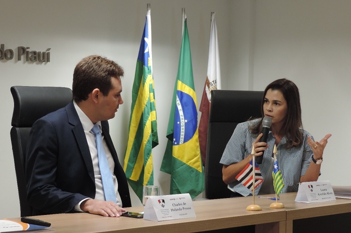 DUas pessoas sentadas atrás de uma mesa 