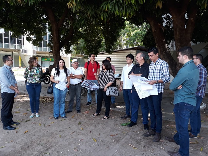 Pessoas de pé olhando projeto