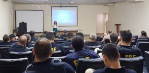 Pessoas sentadas em auditório assistindo palestra
