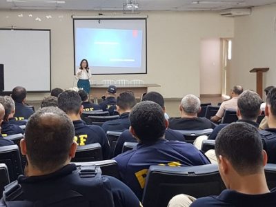 Pessoas sentadas em auditório assistindo palestra