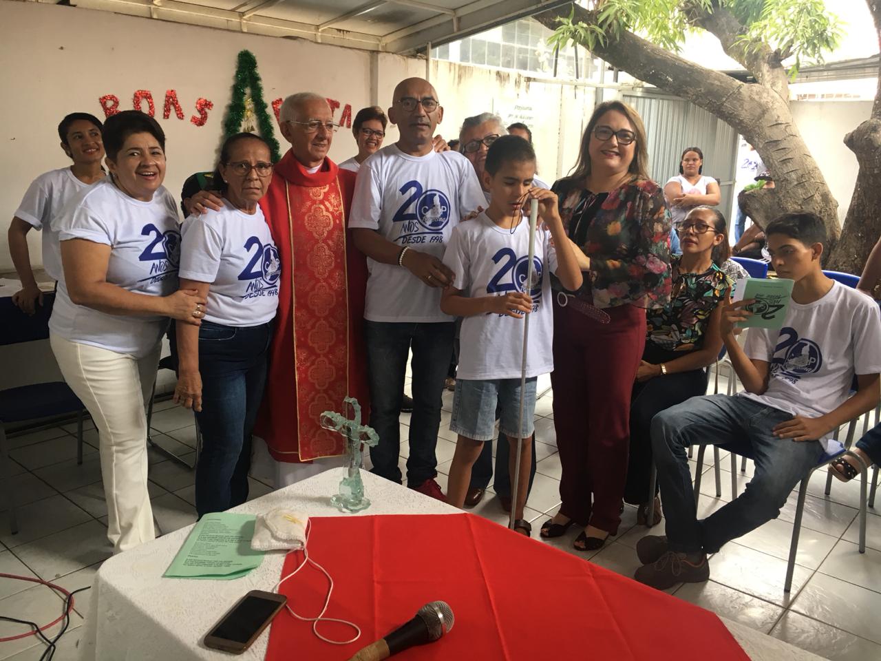 Promotora de Justiça em solenidade, rodeada por muitas pessoas que trajam camisetas com o dizeres 