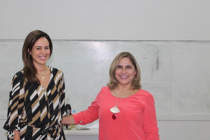 Duas mulheres de pé sorrindo 
