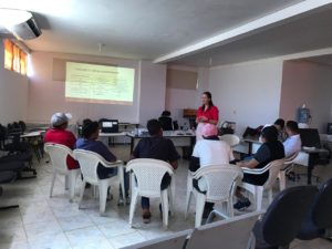 Encontro projeto Reeducar: alguns homens sentados assistem à apresentação da Promotora.
