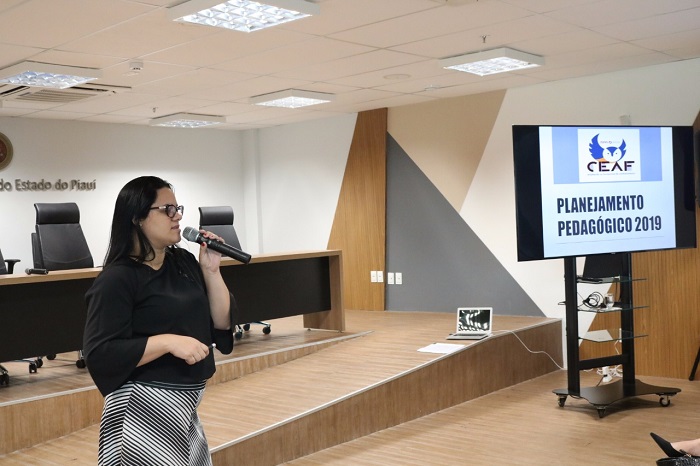 Mulher de pé falando com microfone nas mãos 