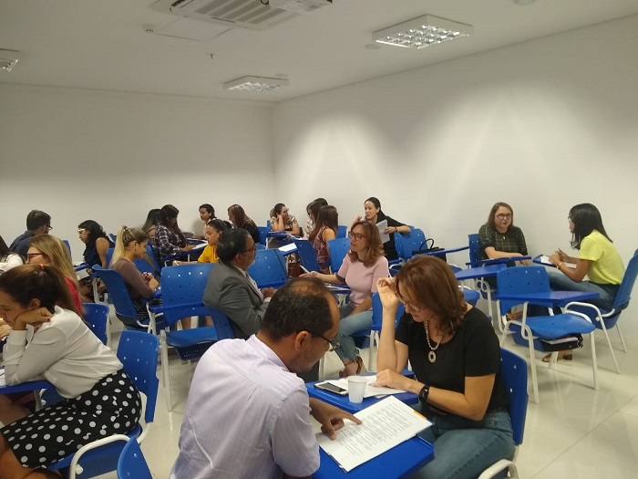 Pessoas sentadas em sala de aula conversando 