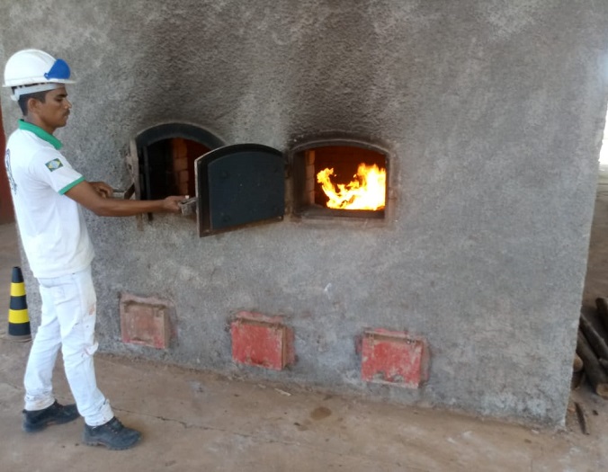Pessoa abrindo um forno onde a droga será incinerada 