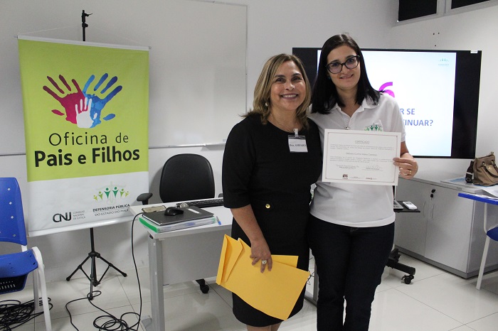Mulheres de pé segurando um certificado 