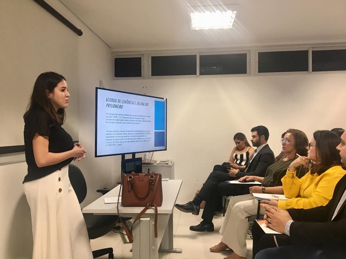 Mulher de pé falando para plateia 