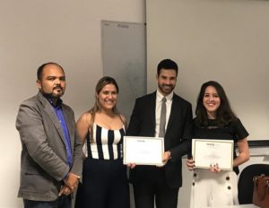 Pessoas de pé segurando certificados