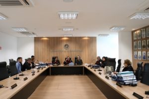Pessoas sentadas em volta de uma bancada