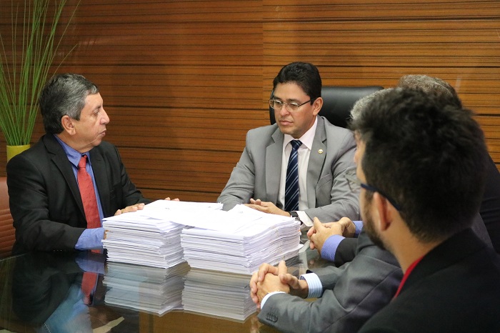 Pessoas sentadas analisando processos de denúncias