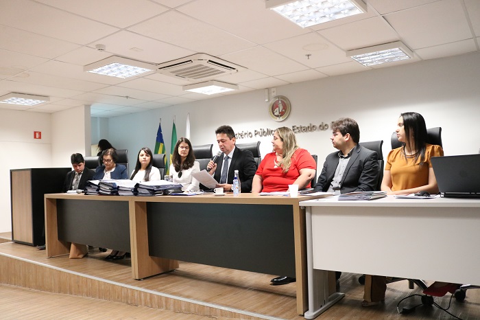 Pessoas sentadas atrás de uma mesa 