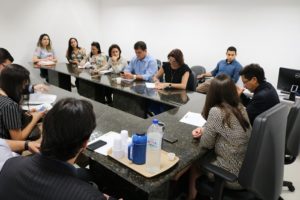 Pessoas sentadas em volta de uma mesa