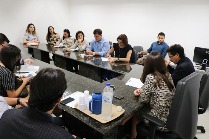 Pessoas sentadas em volta de uma mesa