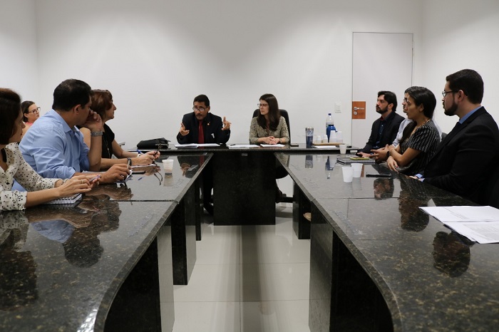 Pessoas sentadas em volta de uma mesa 