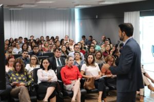 Homem de pé e varias pessoas sentadas