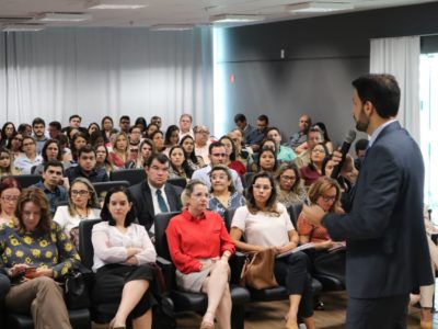 Homem de pé e varias pessoas sentadas