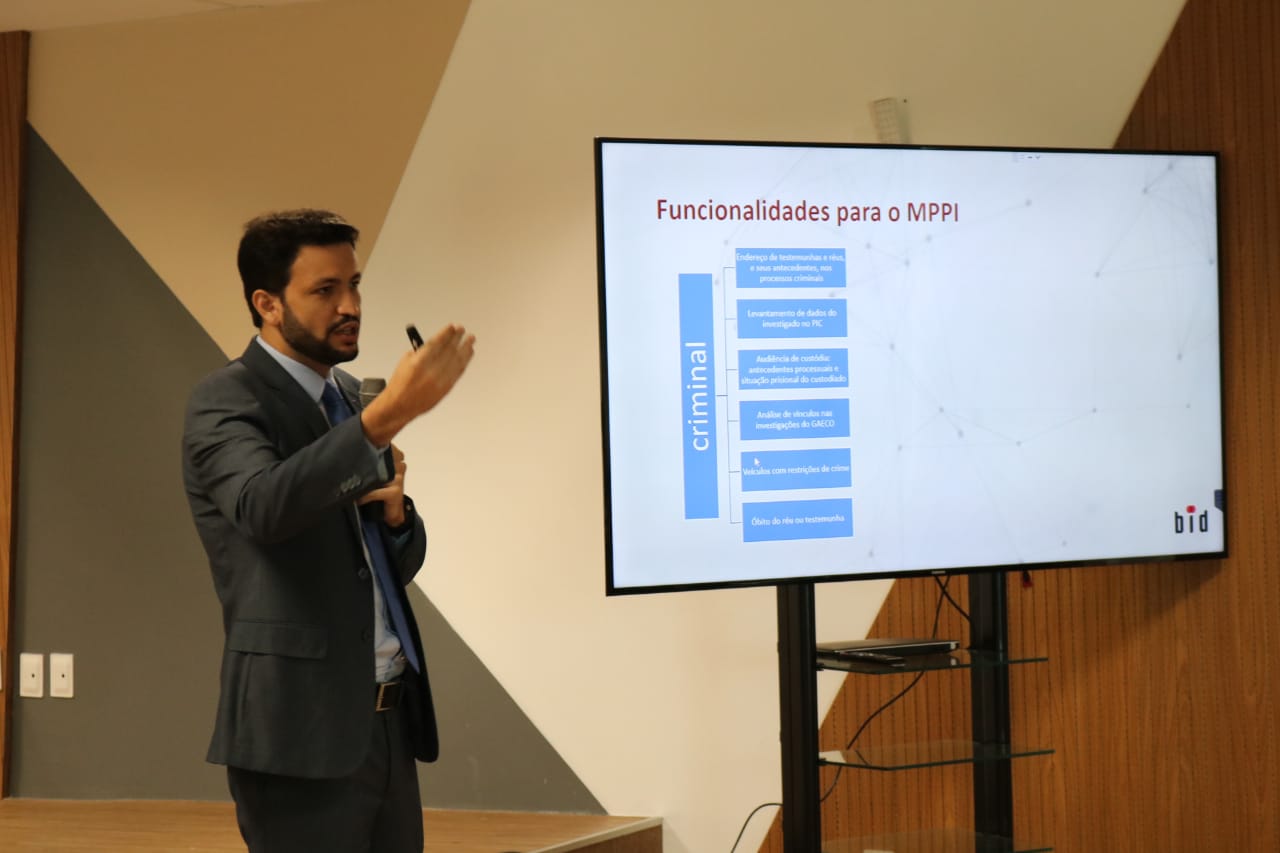 Homem de pé com microfone na mao gesticulando
