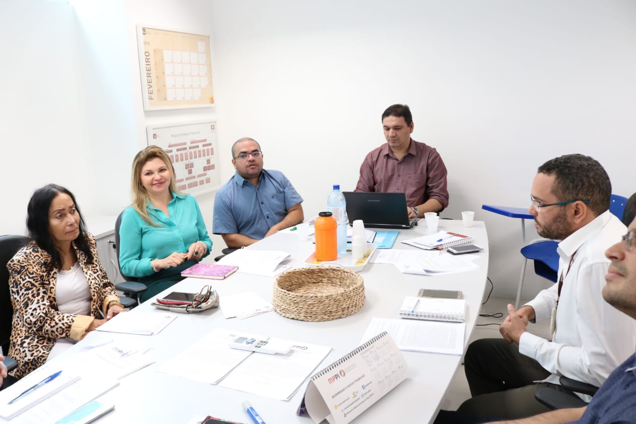 Pessoas sentadas em volta de mesa