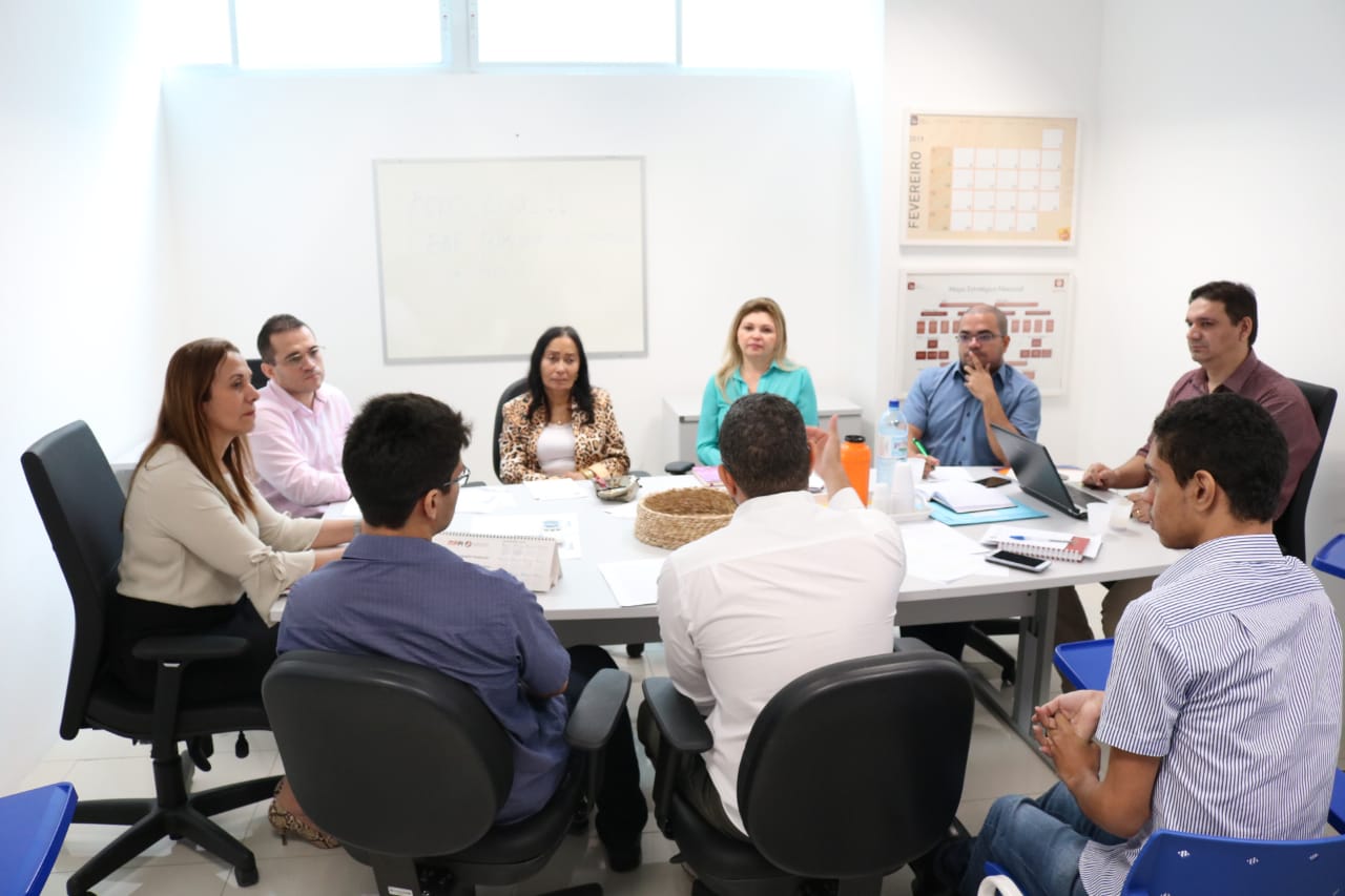 Pessoas sentadas em volta de mesa