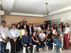 Algumas pessoas de pé e outras sentadas olhando para a foto
