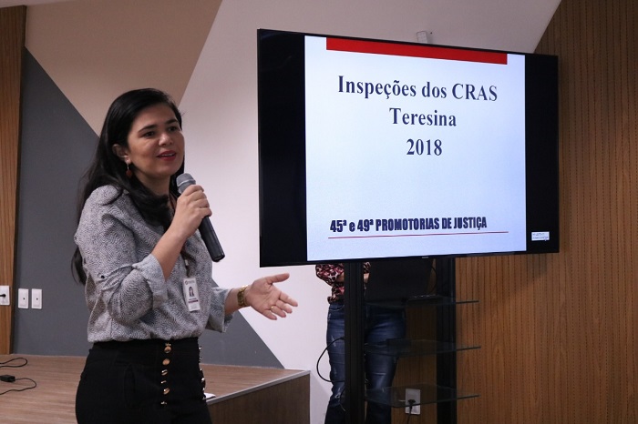 Mulher de pé falando para o público