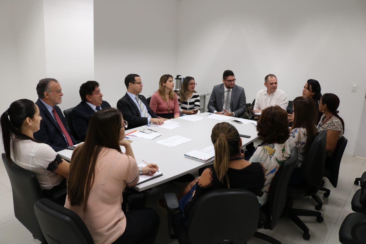 Pessoas sentadas em volta de uma mesa 