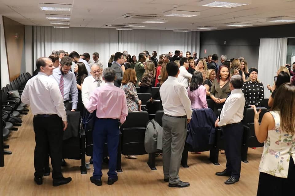 Membros da plateia sorrindo e trocando cumprimentos