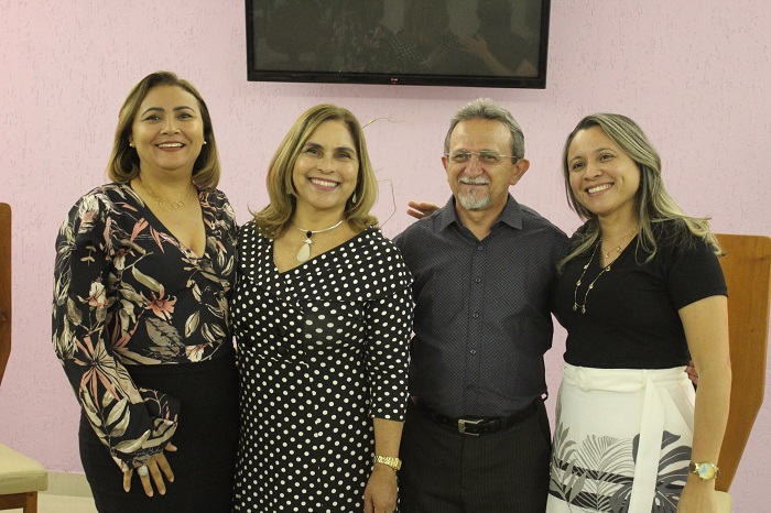 Quatro pessoas de pé e sorrindo para fotografia 