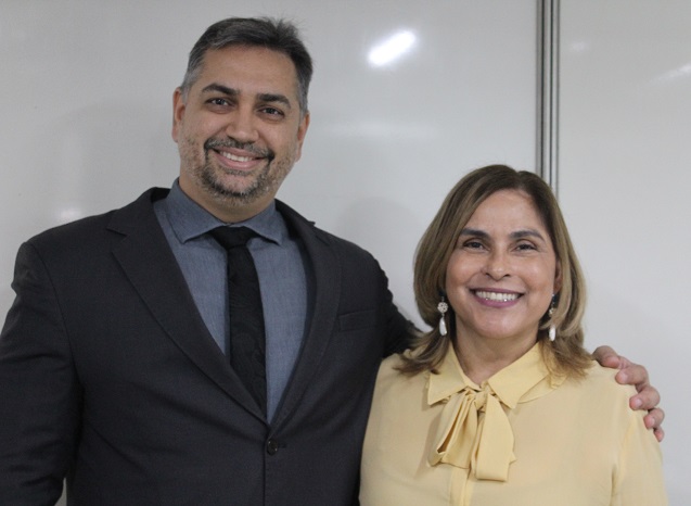 Duas pessoas de pé sorrindo