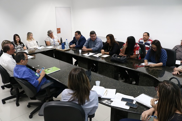 Pessoas sentadas em volta de uma mesa
