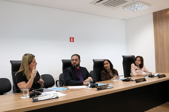Pessoas sentadas em volta de uma mesa 