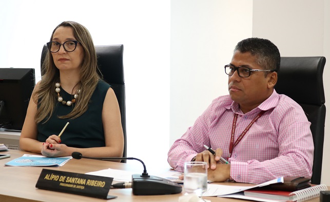 Duas pessoas sentadas atrás de uma mesa 