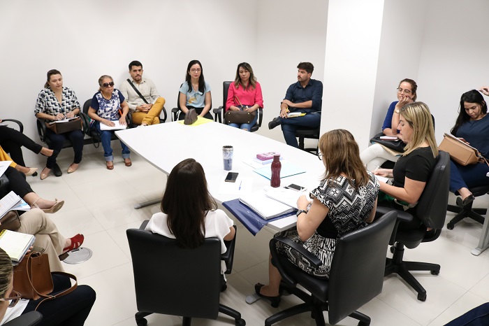 Pessoas sentadas em volta de uma mesa 