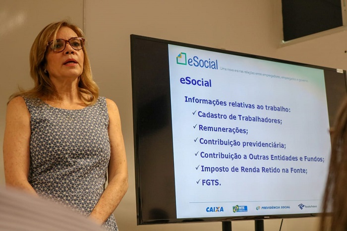 Mulher de pé ao lado de uma tela 