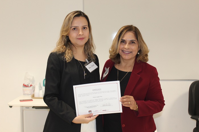 Duas mulheres de pé. As duas seguram um certificado 