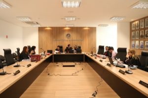 Pessoas sentadas atrás de uma bancada