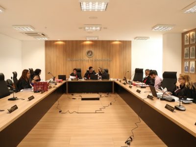 Pessoas sentadas atrás de uma bancada