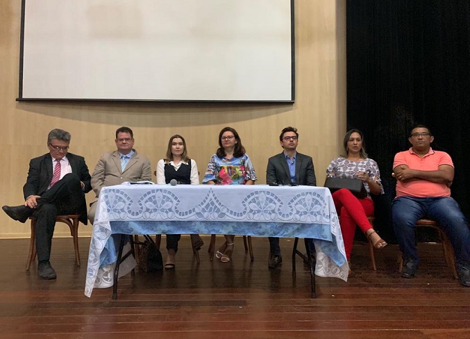 Pessoas sentadas atrás de uma mesa 