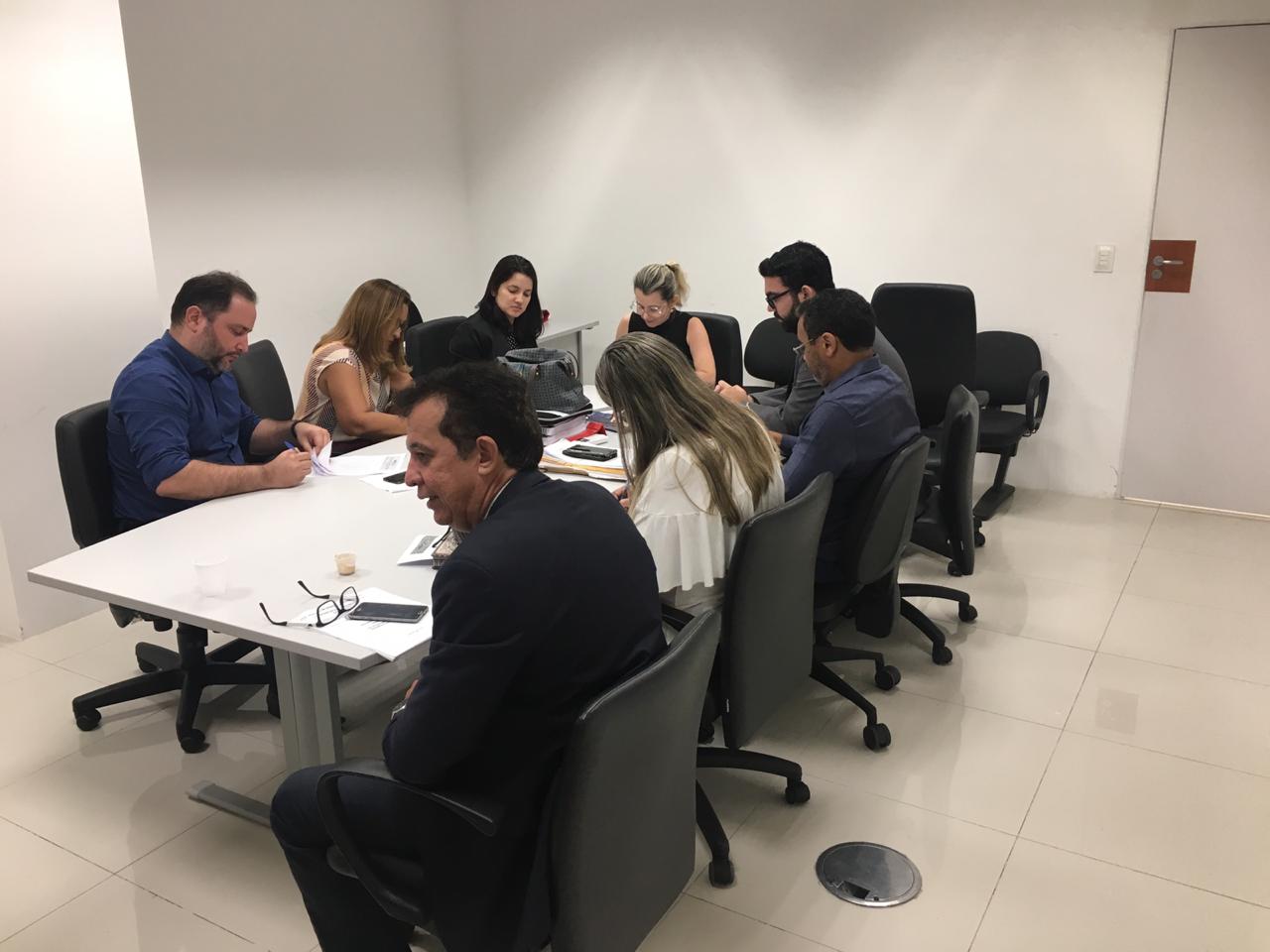 Pessoas sentadas em volta de uma mesa 