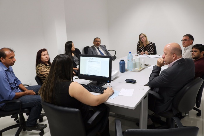 Pessoas sentadas em volta de uma mesa 