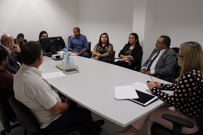 Pessoas sentadas em volta de uma mesa