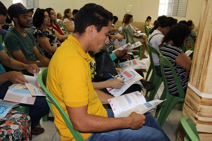 Homem sentando lendo material informativo