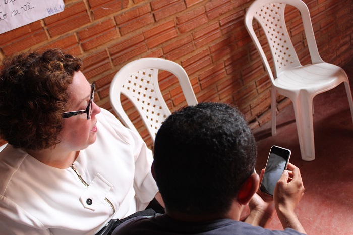 Homem mostra imagem de celular para mulher 