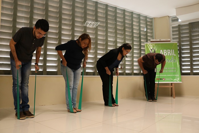 Pessoas de pé fazendo ginástica laboral 