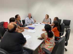 Pessoas sentadas em volta de uma mesa
